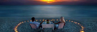 A young couple share a romantic dinner on the beach