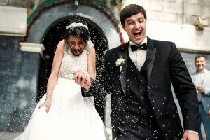 friends throw rice on newlyweds while